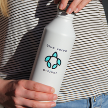 Load image into Gallery viewer, Person holding white stainless steel water bottle with Blue Verve Project logo